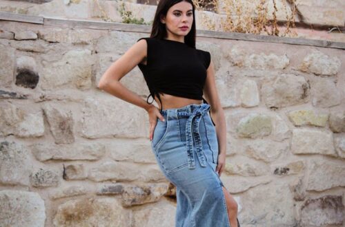 A woman in a crop top and denim skirt