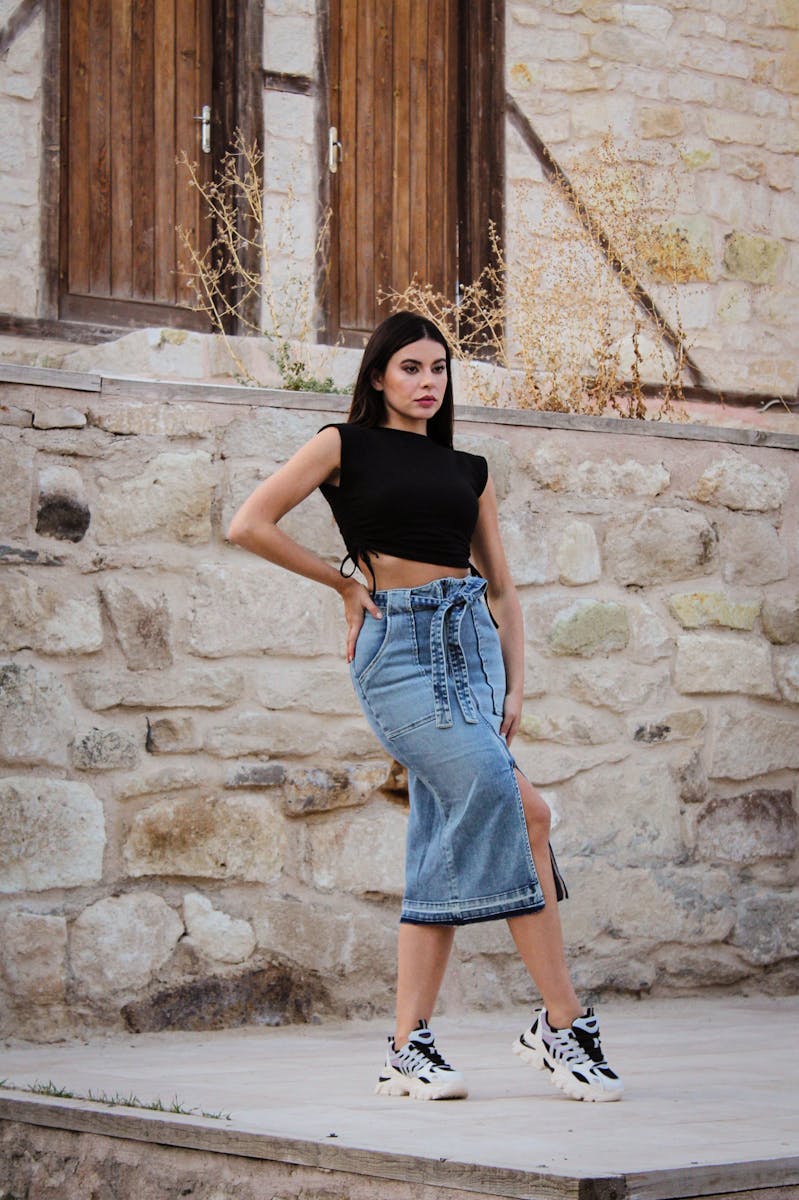 A woman in a crop top and denim skirt