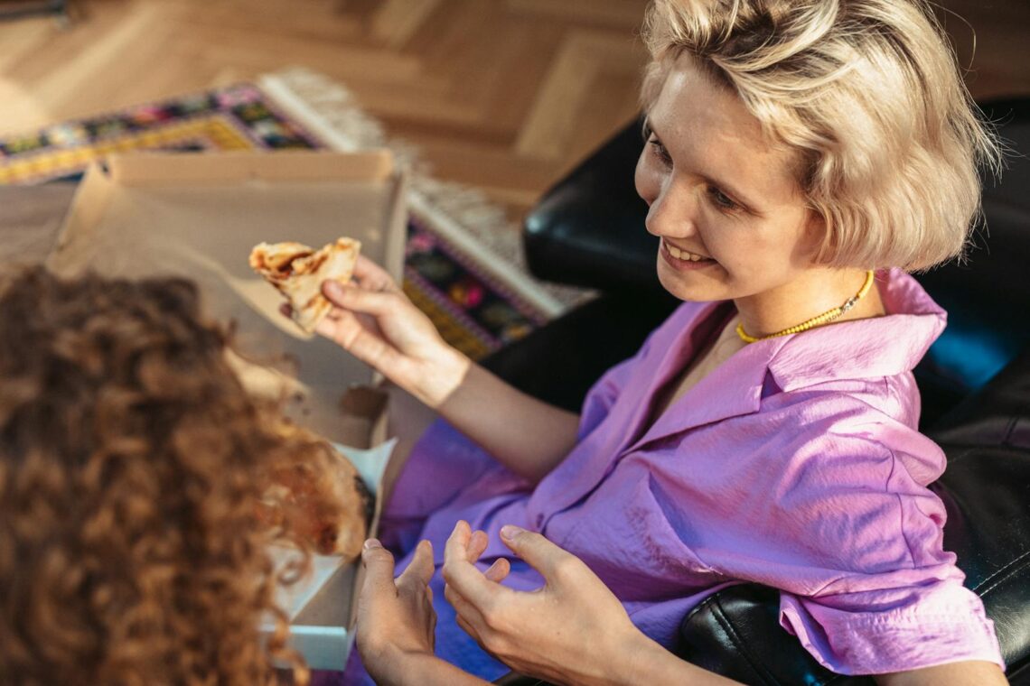 Women Eating Pizza while Talking