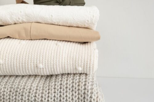 a stack of folded clothes on a white surface