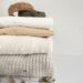 a stack of folded clothes on a white surface